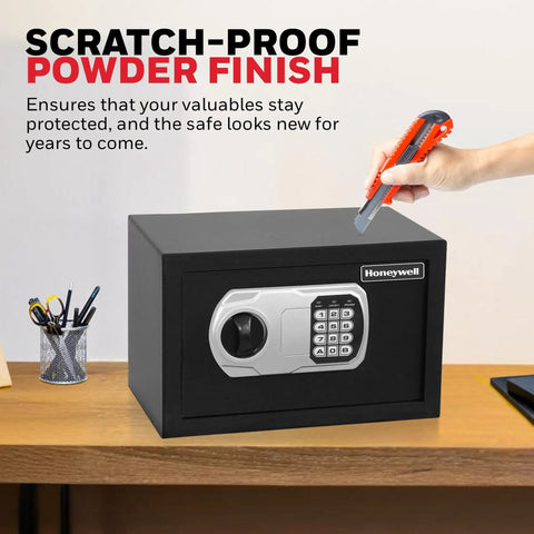 Scratch-proof black compact home safe with digital and key lock, DOJ-approved, 0.28 cu ft, on desk with cutter demonstrating durability.