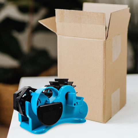 Semi Automatic Heat Tape Cutter With Compact Desktop Packing Station And Lightweight Tape Holder For Quick Box Sealing And Top Shelf Shipping Hustle The Reliable Gadget For Smooth Tape Dispensing Routine Blue next to an open cardboard box.