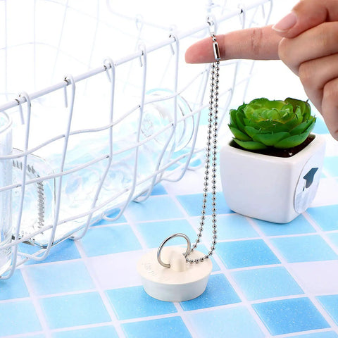Durable Rubber Drain Stopper With Hanging Ring And 30 Centimeter Chain on blue tiled surface, next to decorative plant