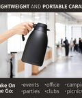 Hand holding 68 Ounce Thermal Coffee Carafe With Insulated Black Stainless Steel Keeps Your Brew Hot 12 Hours Or Cold 36 Hours