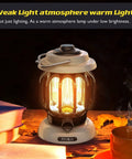 Led Camping Lantern With Rechargeable Battery And Retro Metal Construction, warm light setting, on wooden table with books.