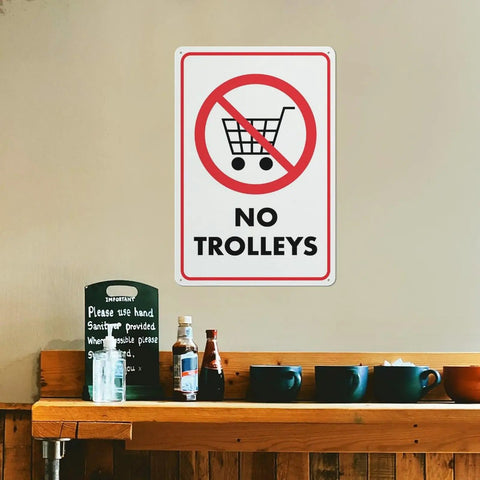 No Trolley Symbol 8 By 12 Warehouse Equipment Restriction Sign in indoor setting above a shelf with bottles and cups.