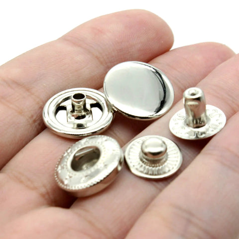 Premium Brass Metal Snap Buttons Fastener Kit With Heavy Duty Tools Silver 15mm showing various snap buttons held in hand.