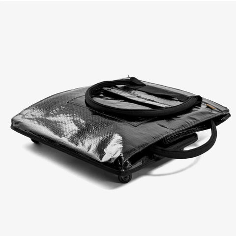 90L Collapsible Rolling Tote With Wheels For Groceries And Laundry, Foldable black utility cart lying flat, side view