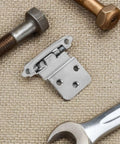 Beefy 4 Pack Heavy Duty Self Closing Hidden Cabinet Door Hinges in iron finish on textured surface with tools