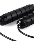 Black handles of adjustable jump rope with ball bearing speed rope for men women kids tangle free skip rope for fast cardio at home gym school.