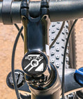 Close-up of a bike headset top cap kit for 1-1/8 inch forks with aluminum alloy construction and steel bolt on handlebars.