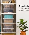 Big Time Seventeen Quart Clear Stackable Storage Bin With Secure Snap Lid For Slick Bedroom Closets Loaded Garages And Wooden Shelving That Gonna Keep Your Setup Tight, stacked on wooden shelf with clothing inside.