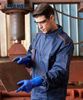 Man wearing Premium Pvc Chemical Gloves With Sturdy Nonslip Grip and Serious Oil Acid Alkali Shield inspecting metal plate.