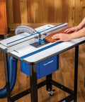 Premium Shop Grade Mid Size Router Lift Kit Featuring Rock Solid Phenolic Table Plate And Slick Quick Swap Snap Lock Ring System in use with wood.