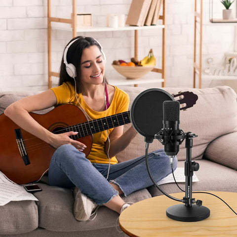 Woman playing guitar next to a multifunctional desktop microphone stand for live streaming and studio recording with pop filter