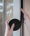 Person applying Rock Solid Open Cell Foam Tape Self Adhesive Sound Insulation Weather Stripping Gap Filler to door frame.