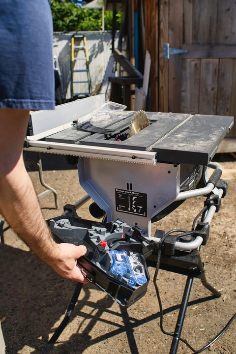 Heavy Duty Compact Table Saw With Patented Skin Contact Safety System And Precision Rack Pinion Fence For Rock Solid Job Site Performance 15 Amp Motor 120 Volt Setup showing operator's hand adjusting settings.
