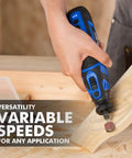 Person using 8V Cordless Rotary Tool Kit with 130 Pcs Accessories on wood carving; 5 speed, 30000 RPM, for sanding and detail work.
