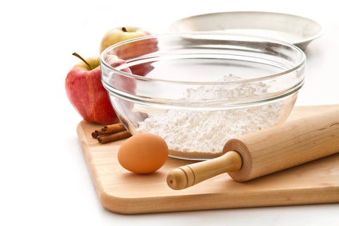Glass bowl with flour beside apples, egg, and rolling pin on cutting board - Flour Keeper Airtight Storage Container For Flour Sugar And Dry Goods 5 Lb Capacity BPA Free Easy Pour Design Built In Leveler For Precise Measuring And Pantry Organization Go To Kitchen Essential