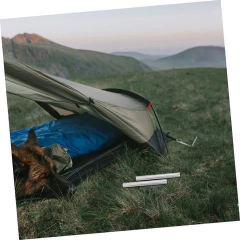 Tent scene with 4 Pack Aluminum Alloy Tent Pole Repair Tubes set beside a tent in a grassy landscape, ideal for quick fixes.