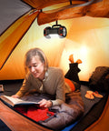 Rechargeable Camping Lantern With 1500 Lumen Output And 8 Lighting Modes hanging in a tent with a person reading.