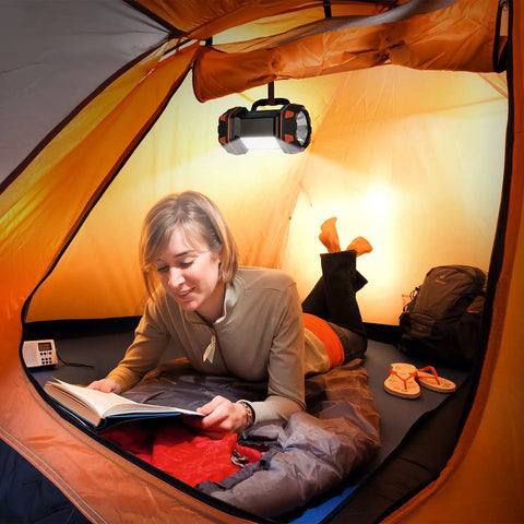 Rechargeable Camping Lantern With 1500 Lumen Output And 8 Lighting Modes hanging in a tent with a person reading.