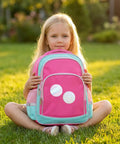 Child holding pink backpack with badges from 200 Piece Set For 2.25 Inch 58mm Button Makers Protective Film With Eight Glitter Styles