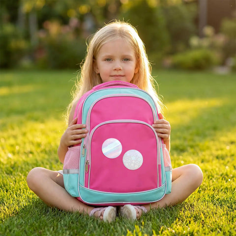 Child holding pink backpack with badges from 200 Piece Set For 2.25 Inch 58mm Button Makers Protective Film With Eight Glitter Styles