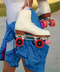 Person holding white and blue roller skates with red 92A quad roller skate wheels durable indoor outdoor replacement anti slip PU PP grippy wheels