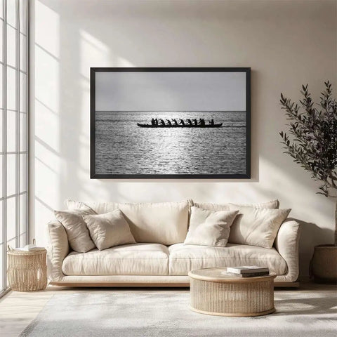 Rowing Team Silhouette Canvas Print With Black Frame above a sofa in a modern living room, minimalist ocean landscape