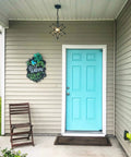 Front porch with Moravian Star Pendant Light With Seeded Glass Shade, Adjustable Chain, 16 Inch Diameter, above turquoise door.