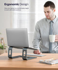All Aluminum Laptop Stand For Desk Setup With Ventilated Cooling Detachable Ergonomic Riser Anti Slip Notebook Holder For 10-16 Inch Laptops Like MacBook, Dell XPS, HP, Lenovo And ThinkPad on a desk with a person in the background