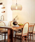 Real Deal Plug In Pendant Light Featuring Woven Rattan Shade And Hassle Free On Off Switch illuminating a dining table.