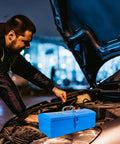 Heavy Duty Blue Metal Toolbox For Mechanics Portable Storage Case on a car hood during nighttime repairs.