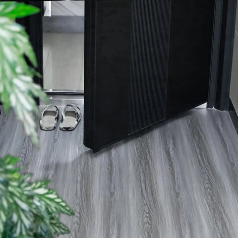 Real Wood Look Vinyl Floor Roll Featuring Dead Simple Peel And Stick Setup Super Wide Layout For Quick Room Makeovers Non Slip Grip and Totally Slick Resilient Surface For Heavy Daily Traffic laid out in an entrance area with slippers.