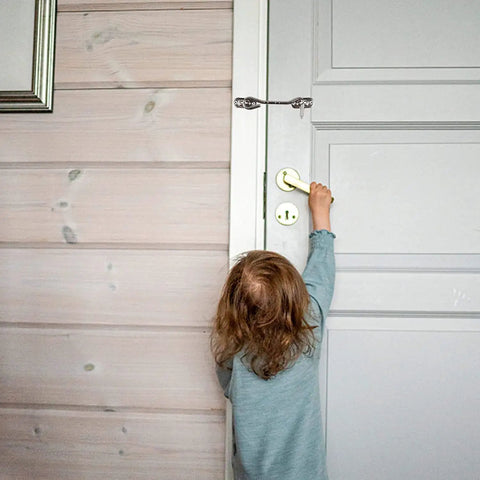 Child reaching for a brass doorknob with a Stainless Steel Heavy Duty Gate Hook and Eye Latch for Door Window Cabinet visible.