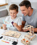 Hands On Robotic Arm Kit For Kids And Teens Aged 8 To 16, Totally Fun Kid Friendly STEM Toy For Learning Coding, Motors, Microcontroller, Circuits, And DIY Engineering Projects. father and son assembling wooden robotic arm kit on table