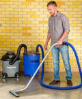 Heavy Duty Shop Vacuum Floor Sweep Attachment With Flexible Swivel Head And Angled Neck Designed To Scoop Sawdust And Floor Grit Under Workbenches Gonna Keep Your Shop Spotless being used by a man.