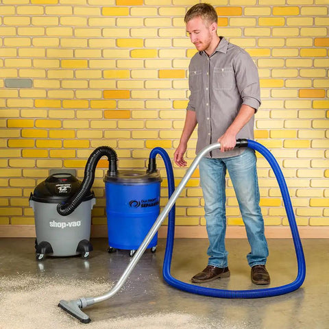 Heavy Duty Shop Vacuum Floor Sweep Attachment With Flexible Swivel Head And Angled Neck Designed To Scoop Sawdust And Floor Grit Under Workbenches Gonna Keep Your Shop Spotless being used by a man.