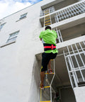 Person using 32 Ft Fire Escape Rope Ladder For Four Story Homes With Spring Hooks And Safety Cord Emergency Escape Ladder Life Saving Fire Rescue Tool Ready No Brainer Safe Escape For Any Fire Breaks And Family Safety At Home on building exterior