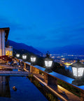 Night view with Outdoor Solar Powered Post Cap Lights For 4x4 Wood Posts, illuminating a deck with a scenic mountain background.