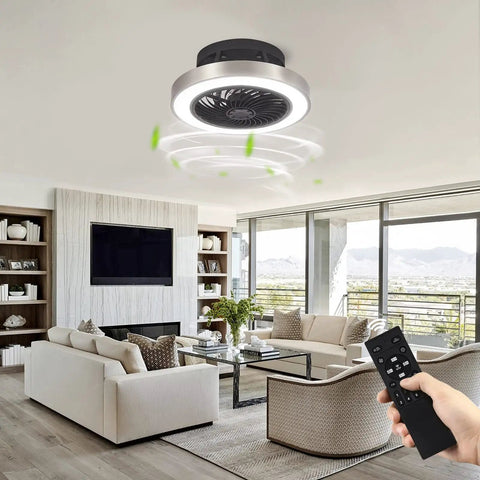 Enclosed 16 Inch Flush Mount Ceiling Fan With Lights in living room, remote in hand, dope black and brushed nickel finish