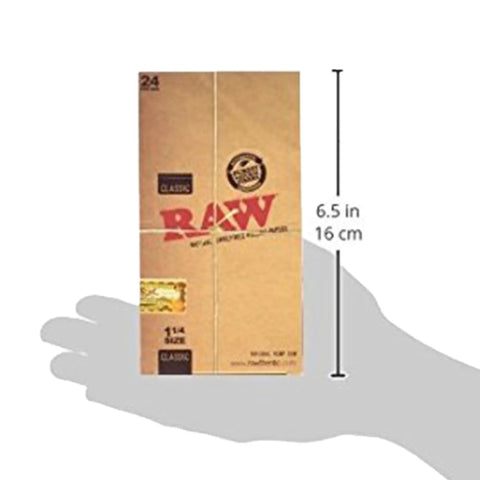 Hand holding Unrefined Classic 1 And A Quarter Size Cigarette Rolling Papers Full Box 24 Packs 1200 Ultra Thin Translucent 75mm By 44mm Natural Gum Additive Free All Natural Vegan Made In Spain, 6.5 inches tall.