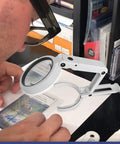 Person using Premium Pro Grade LED Magnifying Glass And Centering Tool For Sports Card Grading Kit over a trading card