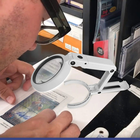 Person using Premium Pro Grade LED Magnifying Glass And Centering Tool For Sports Card Grading Kit over a trading card