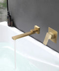 Gold wall mount tub filler with lever handle and waterfall spout over bathtub