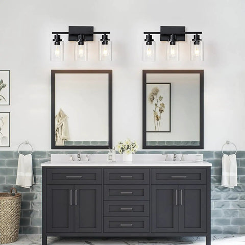 Top Shelf Matte Black Three Light Bathroom Vanity Fixtures With Clear Glass Shades, mounted above dual mirrors in modern bathroom.