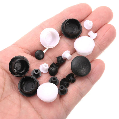 Hand holding black and white plastic snap-in screw hole plugs, various sizes, similar to highlighted 100 Pack Plastic Snap In Screw Hole Plugs 6mm Diameter Flush Shelf Button Caps For Furniture Cabinet Cupboard Dark Brown Durable Fits 5mm Under Head And 11.5mm Cap Diameter Keeps Surfaces Clean And Neat.