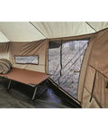 Interior view of Base Camp Tent For All Weather Adventures With Stove Jack Four Season Camping showing cot, window, and beige fabric.