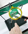 Helping Hands Soldering Station with 3X Magnifying Glass in use for precise electronics soldering, supported by flexible arms.