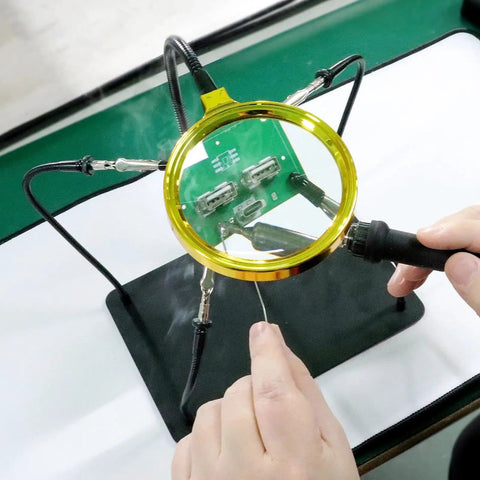 Helping Hands Soldering Station with 3X Magnifying Glass in use for precise electronics soldering, supported by flexible arms.