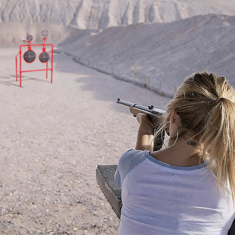 Person aiming at Double Spinner Shooting Targets Three Eighths Inch Thick Steel Auto Reset Target System with mountain backdrop.