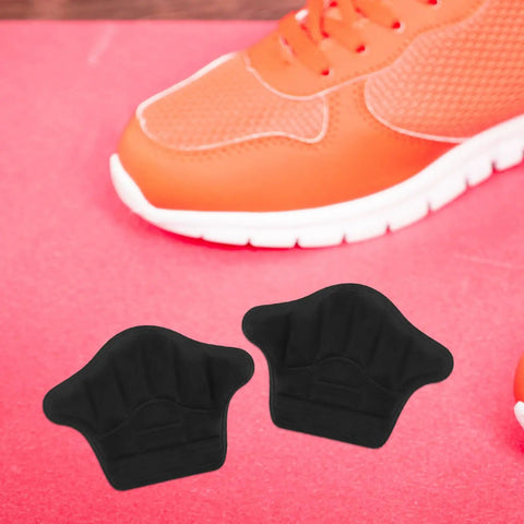 Premium Heel Grips Insert Kit locks your shoes in place. Black foam heel pads for sneakers on pink background.