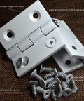 Whisper Quiet Two Point Five Inch Aluminum Door Hinges Four Pack For Cabinets Windows And Furniture Doors With Plastic Bushings Heavy Duty Mortise Hardware Low Dust Reduction, showing white hinges with screws on brown background.